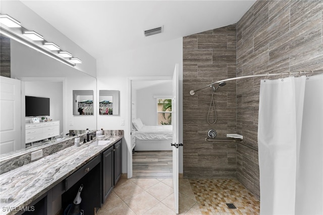 bathroom with a shower with shower curtain, tile patterned floors, and vanity