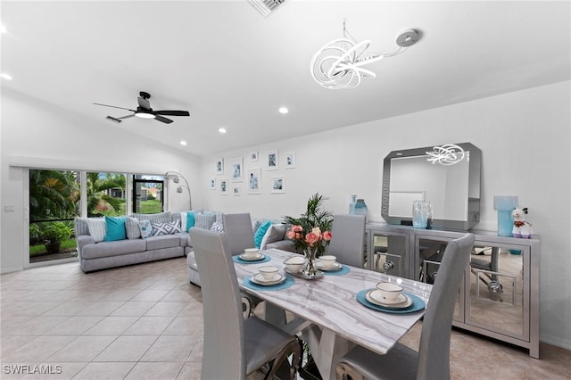 tiled dining area featuring ceiling fan with notable chandelier and vaulted ceiling