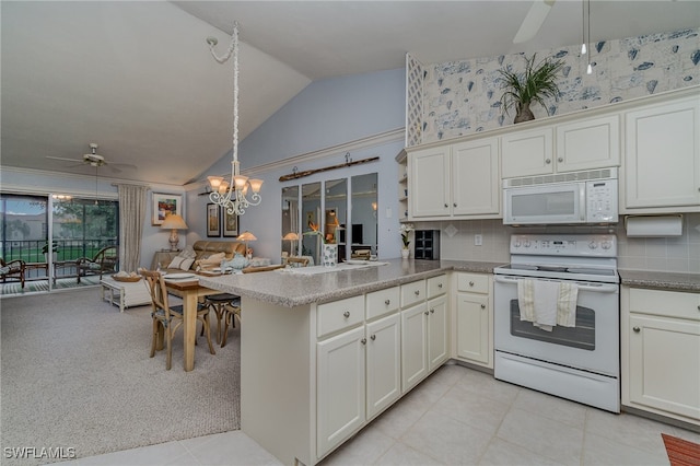 kitchen with kitchen peninsula, light carpet, white appliances, vaulted ceiling, and white cabinetry