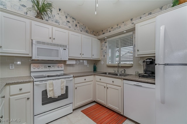 kitchen with tasteful backsplash, sink, white cabinets, and white appliances