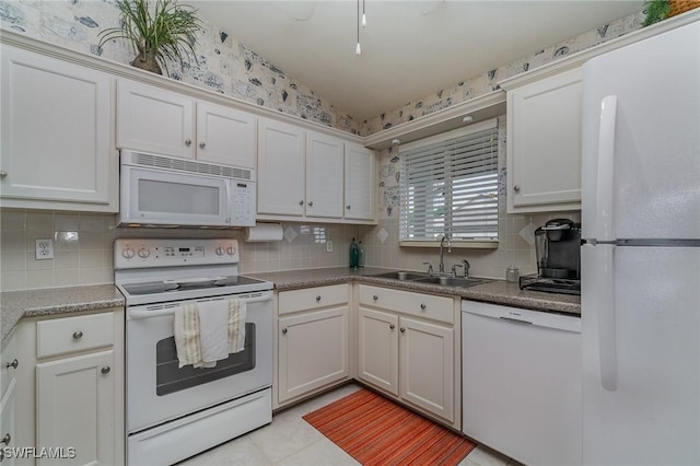 kitchen featuring white appliances, white cabinetry, a sink, and backsplash