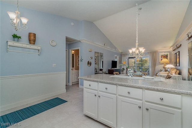 kitchen with white cabinetry, a chandelier, light countertops, and open floor plan