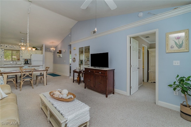 carpeted living room featuring ceiling fan with notable chandelier, ornamental molding, and vaulted ceiling