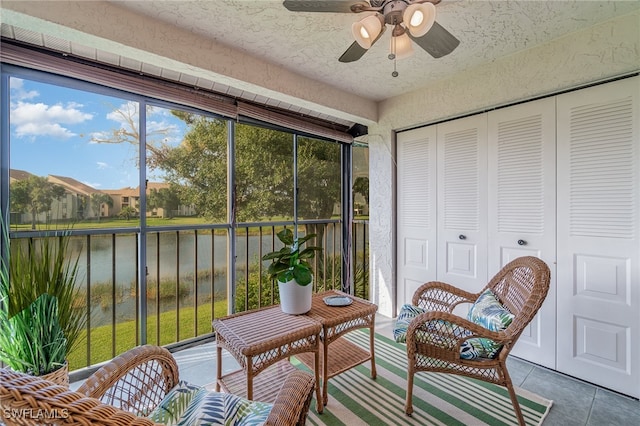 sunroom with a water view, a wealth of natural light, and ceiling fan