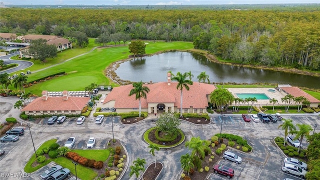 bird's eye view with golf course view, a water view, and a wooded view