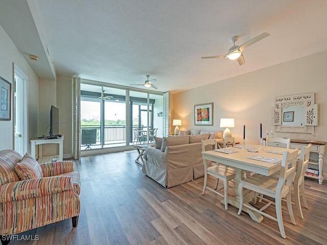 living room featuring ceiling fan, hardwood / wood-style flooring, and expansive windows