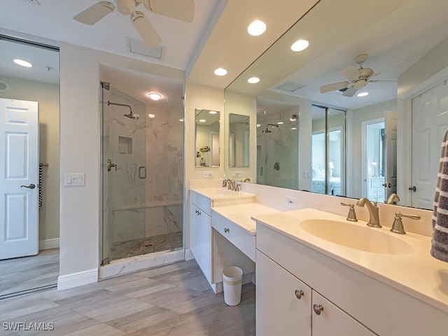 bathroom with ceiling fan, a shower with shower door, and dual bowl vanity