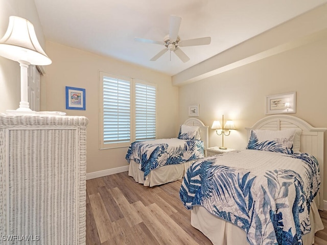 bedroom with baseboards, ceiling fan, and light wood-style floors