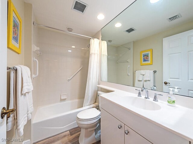 full bathroom featuring shower / bath combination with curtain, toilet, hardwood / wood-style flooring, and vanity