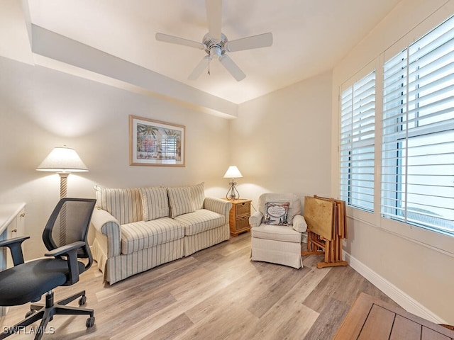 interior space featuring a ceiling fan, baseboards, and light wood finished floors