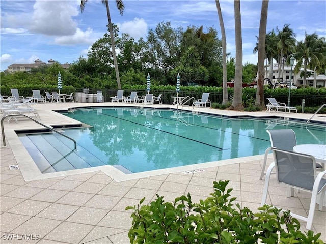 pool featuring a patio area and fence