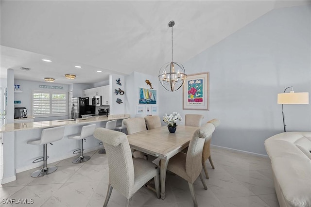 dining area with vaulted ceiling, sink, and a notable chandelier