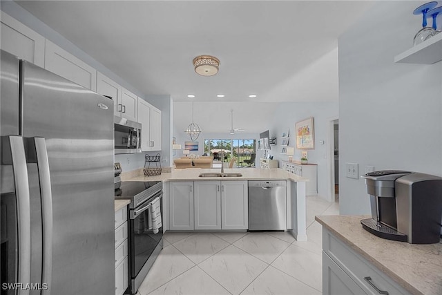 kitchen with white cabinets, kitchen peninsula, sink, and stainless steel appliances