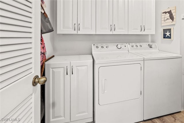 laundry room with light hardwood / wood-style floors, cabinets, and washing machine and clothes dryer