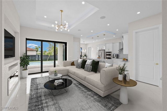 living room with a tray ceiling and a notable chandelier