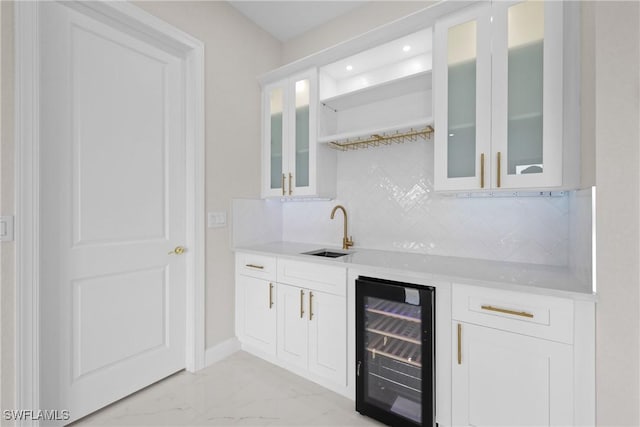 bar with wine cooler, sink, tasteful backsplash, and white cabinets