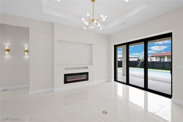 unfurnished living room with a tray ceiling and a notable chandelier