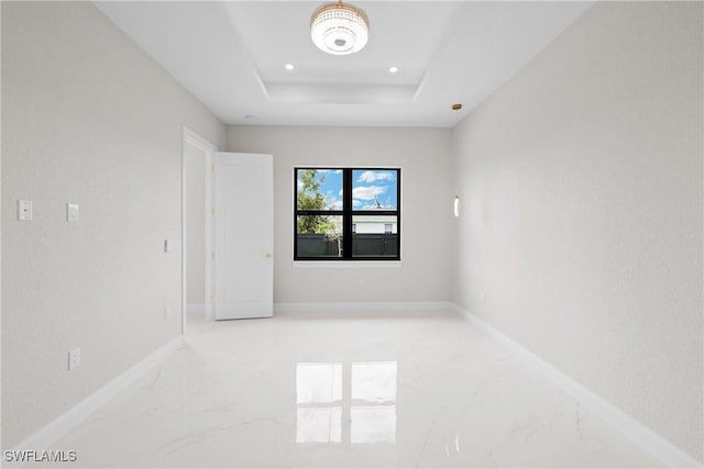 unfurnished room with a raised ceiling