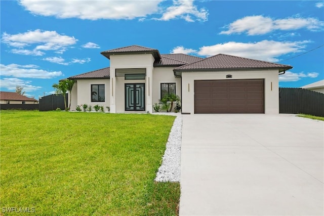 mediterranean / spanish home with a garage and a front lawn