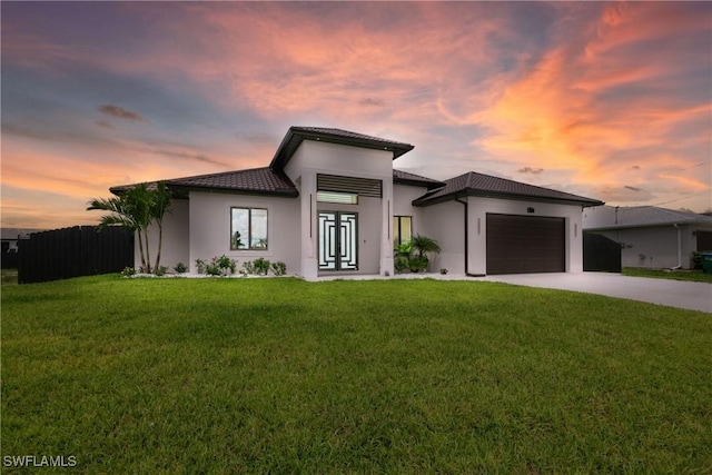 view of front of home featuring a garage and a yard