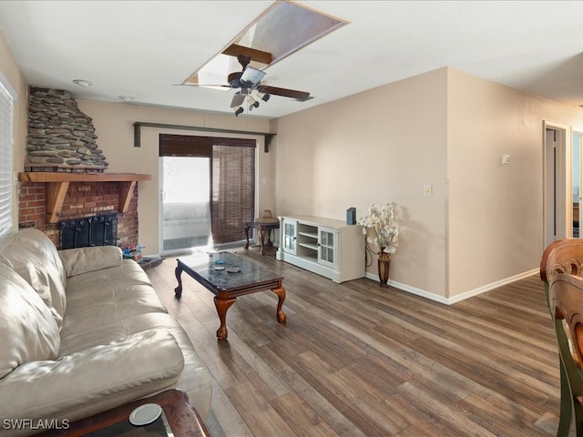 living room with ceiling fan, hardwood / wood-style flooring, and a brick fireplace