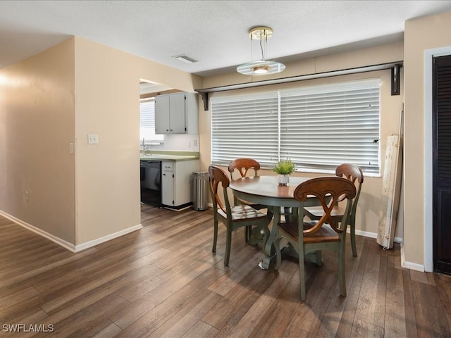 dining area featuring sink, a textured ceiling, and dark hardwood / wood-style floors