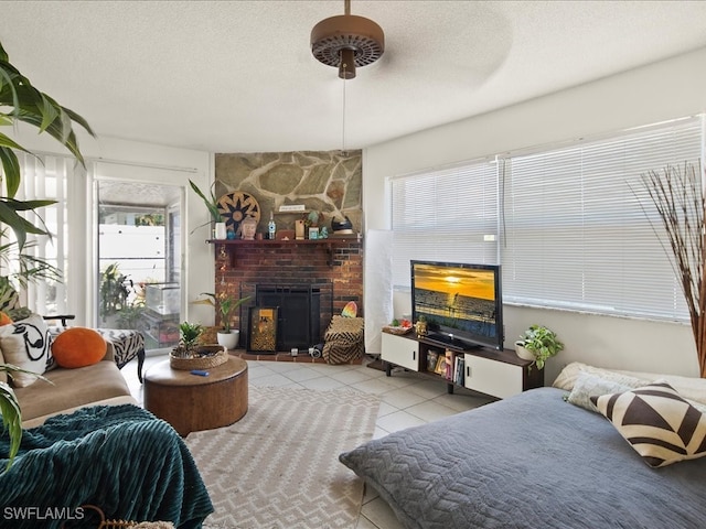 living room featuring a fireplace, a textured ceiling, and light tile patterned floors