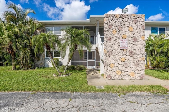 2504 SE 16th Pl Unit 101, Cape Coral, FL 33904 - view of front facade featuring a sunroom and a front yard