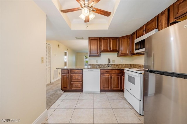 2504 SE 16th Pl Unit 101, Cape Coral, FL 33904 - kitchen with white appliances, a raised ceiling, a ceiling fan, dark stone countertops, and light tile patterned floors
