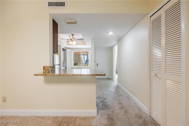 2504 SE 16th Pl Unit 101, Cape Coral, FL 33904 - kitchen with carpet floors, ceiling fan, freestanding refrigerator, a peninsula, and baseboards