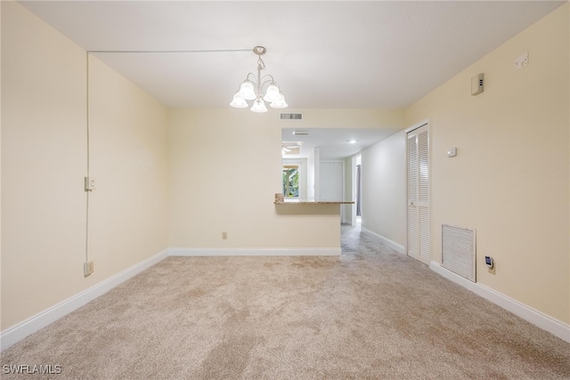 unfurnished room with light carpet and a chandelier