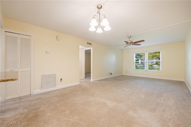 carpeted empty room with ceiling fan with notable chandelier