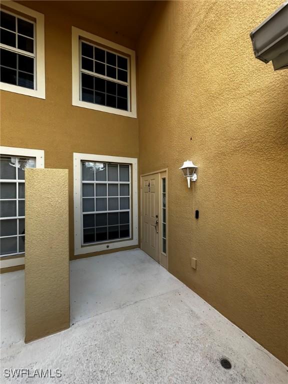 view of exterior entry featuring a patio and stucco siding