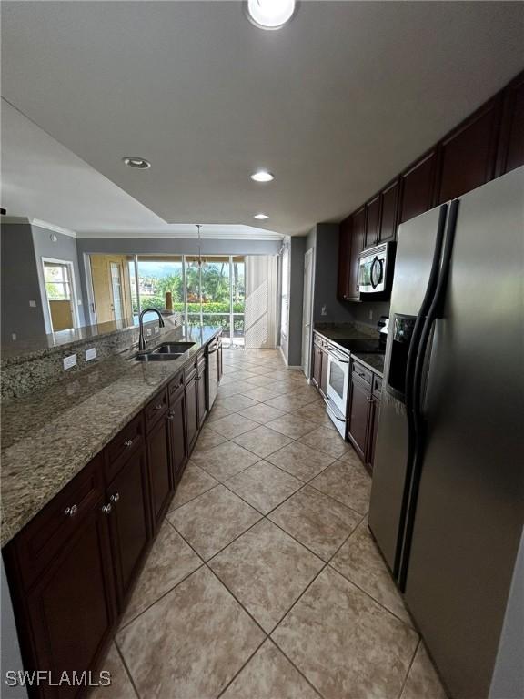 kitchen with light stone counters, light tile patterned flooring, stainless steel appliances, a sink, and dark brown cabinets