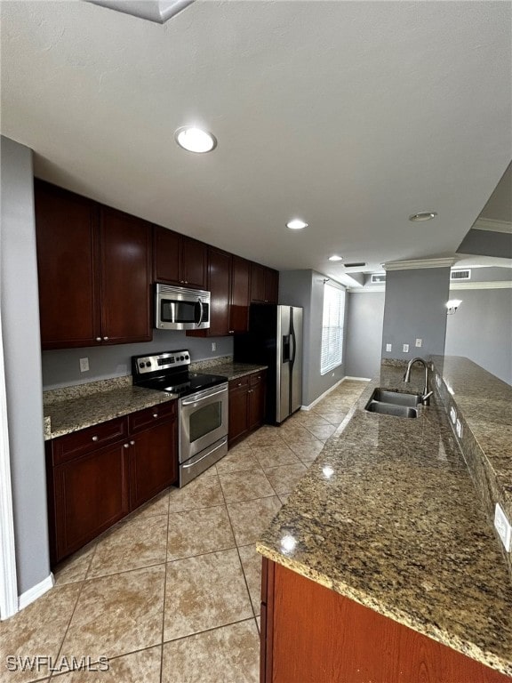 kitchen featuring sink, kitchen peninsula, stainless steel appliances, light tile patterned floors, and stone countertops