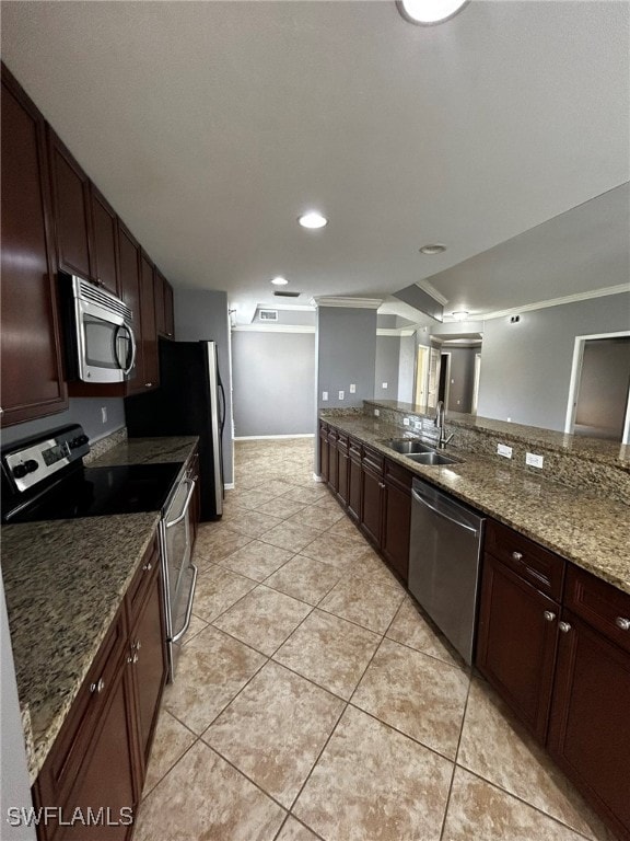 kitchen with appliances with stainless steel finishes, light tile patterned floors, stone counters, ornamental molding, and sink