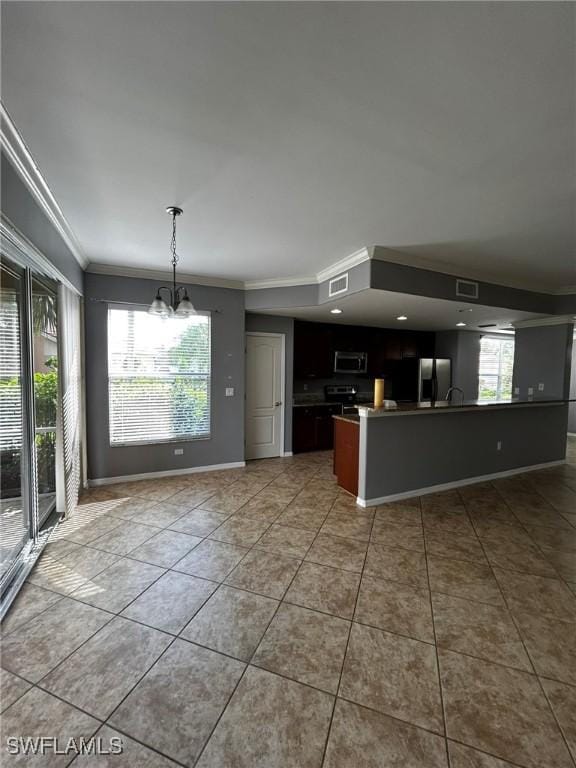 kitchen featuring light tile patterned floors, open floor plan, fridge with ice dispenser, ornamental molding, and stainless steel microwave