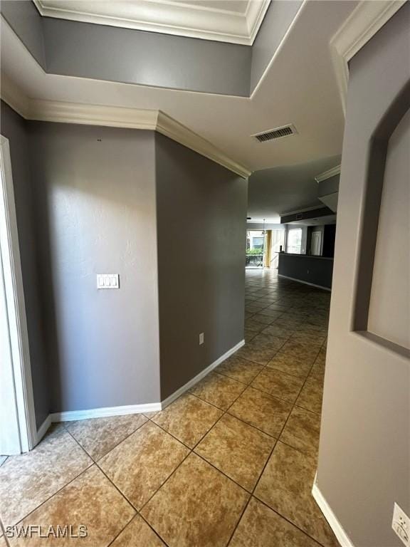 corridor featuring tile patterned flooring, visible vents, and crown molding