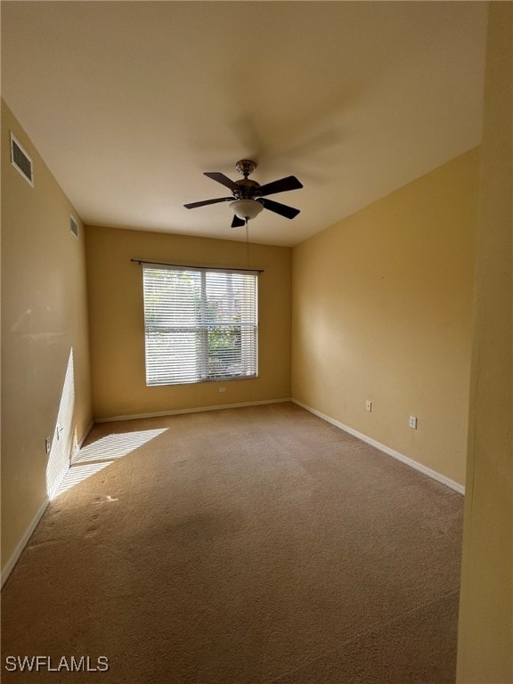 carpeted spare room with ceiling fan