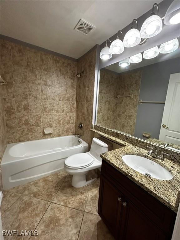 full bathroom featuring tiled shower / bath combo, tile patterned flooring, vanity, and toilet