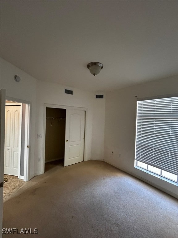 unfurnished bedroom with light colored carpet