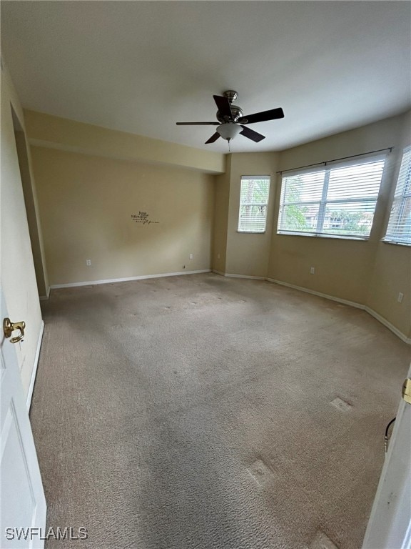 spare room featuring ceiling fan and carpet