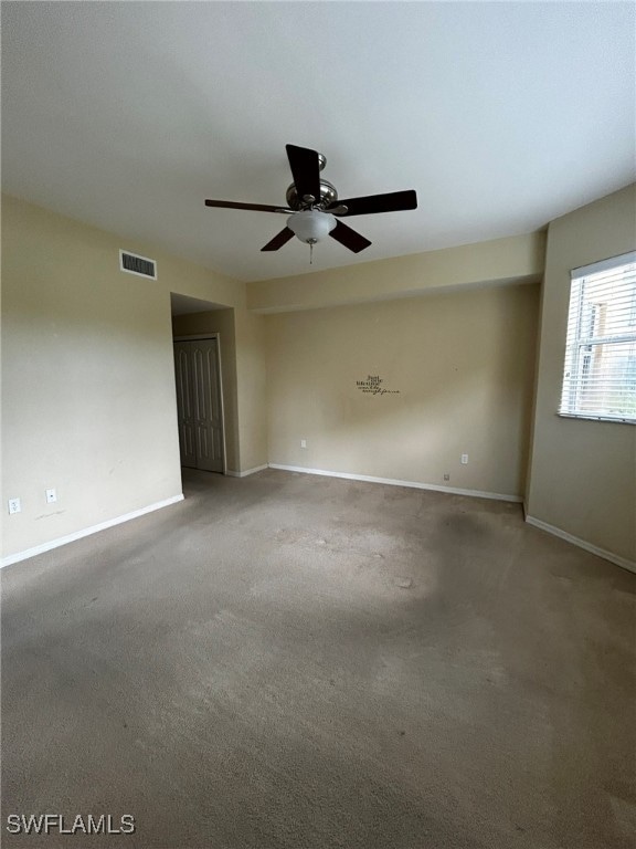 spare room featuring carpet and ceiling fan