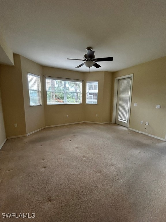 empty room featuring ceiling fan and light colored carpet