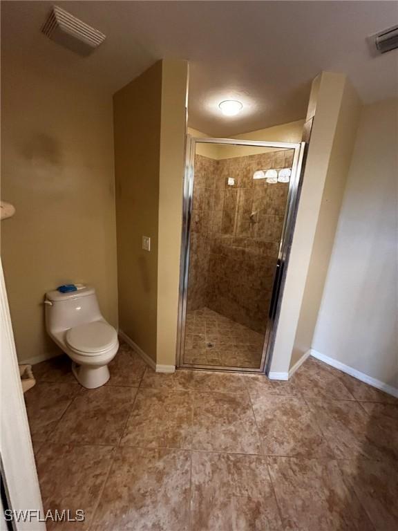 bathroom with visible vents, a shower stall, and toilet