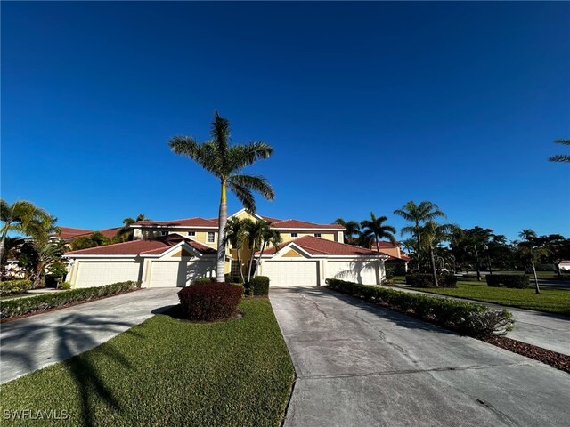 mediterranean / spanish-style home featuring driveway and a front lawn