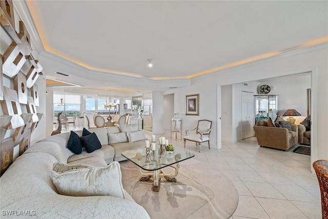 tiled living room with a tray ceiling and a notable chandelier