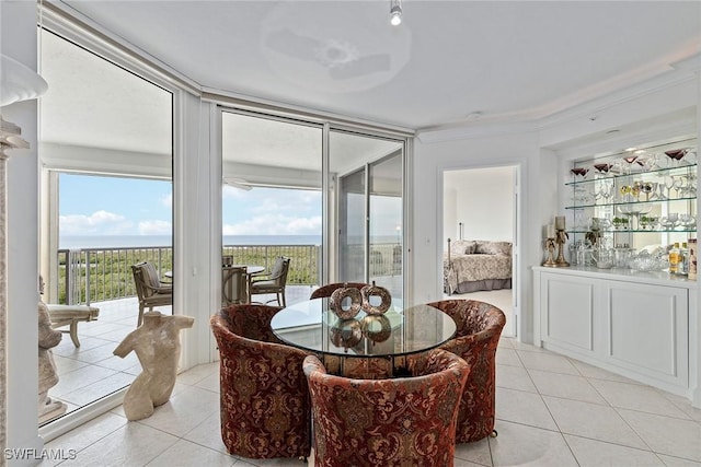 dining room with a water view and light tile patterned floors