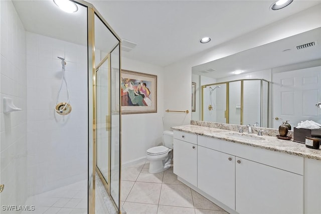 bathroom with tile patterned flooring, vanity, toilet, and a shower with shower door