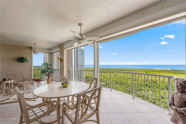 interior space with a water view and ceiling fan